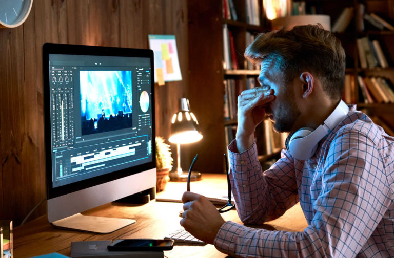 Person wearing SYMI blue light glasses while working on a computer